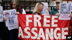 Supporters of WikiLeaks founder Julian Assange stand outside of the Ecuadorian embassy as Assange addresses the media, in London, May 19, 2017.
