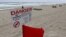A red flag flies after lifeguards closed the area for swimming because of dangerous rip currents, as winds from Hurricane Sandy began to affect weather in Deerfield Beach, Florida, October 25, 2012.