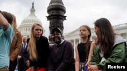 Swedish youth climate activist Greta Thunber, 16, sits on the side among other youth climate activists at a news conference about the Green New Deal hosted by U.S. Senator Ed Markey (D-MA) in front of the U.S. Capitol in Washington, Sept. 17, 2019.