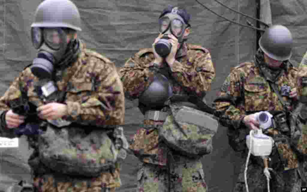 Japan Self-Defense Force officers prepare for a clean-up at a radiation affected area in Nihonmatsu, Fukushima Prefecture in northern Japan, March 15, 2011 – (Reuters)