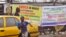 People pass by Ebola virus health warning signs, in the city of Monrovia, Liberia, Aug. 17, 2014. 