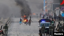 FILE - Protesters burn tires after Mozambique's ruling party, FRELIMO, retains power in contested election in Maputo, Oct. 24, 2024.