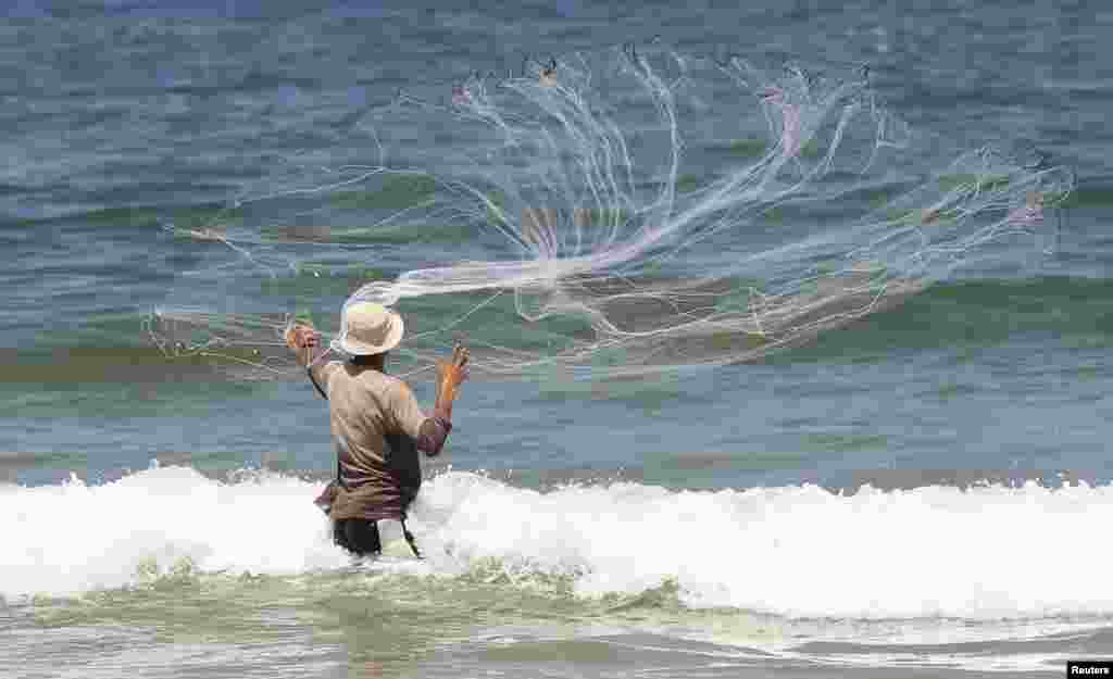 A Palestinian fisherman casts his net at a beach in Gaza City. Israel permits Gaza fishermen to head out to sea from 3 miles to 6 miles, restoring a limit it cut in half two months ago in response to rocket fire from the Palestinian enclave.