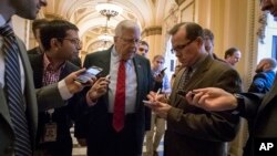 Reporters interview Sen. Mike Enzi, R-Wyo., chairman of the Senate Budget Committee, as arrives to meet with House Ways and Means Committee Chairman Kevin Brady, R-Texas, at the Capitol to advance the GOP tax bill, in Washington, Dec. 15, 2017.