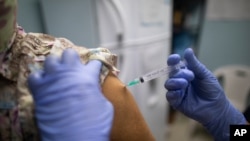 Una enfermera inocula a un trabajador de la salud con una dosis de la vacuna Sinopharm COVID-19 en un centro de salud del programa de salud del gobierno en Caracas, Venezuela. Marzo 7, 2021. Foto: AP.