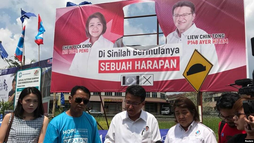 Anggota parlemen oposisi Liew Chin Tong dari Partai Aksi Demokratis (DAP) berbicara di depan spanduk pemilu, setelah gambar pemimpin oposisi Mahathir Mohamad dipotong, di Johor, Malaysia 30 April 2018 di foto ini diperoleh dari media sosial. (Liew Chin Tong/via REUTERS)