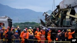 Radnici hitnih službi na mestu sudara dva voza u Indoneziji (AP Photo/Achmad Ibrahim)