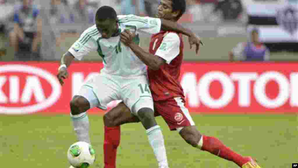 Nigeria's Anthony Ujah, left, is challenged by Tahiti's Henri Caroine during the Confederations Cup match between Tahiti and Nigeria.