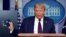 President Donald Trump holds a face mask as he speaks during a news conference at the White House, July 21, 2020.