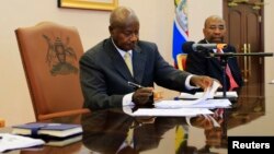 Uganda President Yoweri Museveni signs an anti-homosexual bill into law at the state house in Entebbe, 36 km (22 miles) south west of capital Kampala February 24, 2014. Museveni signed into law on Monday an anti-gay bill that toughens already strict legis