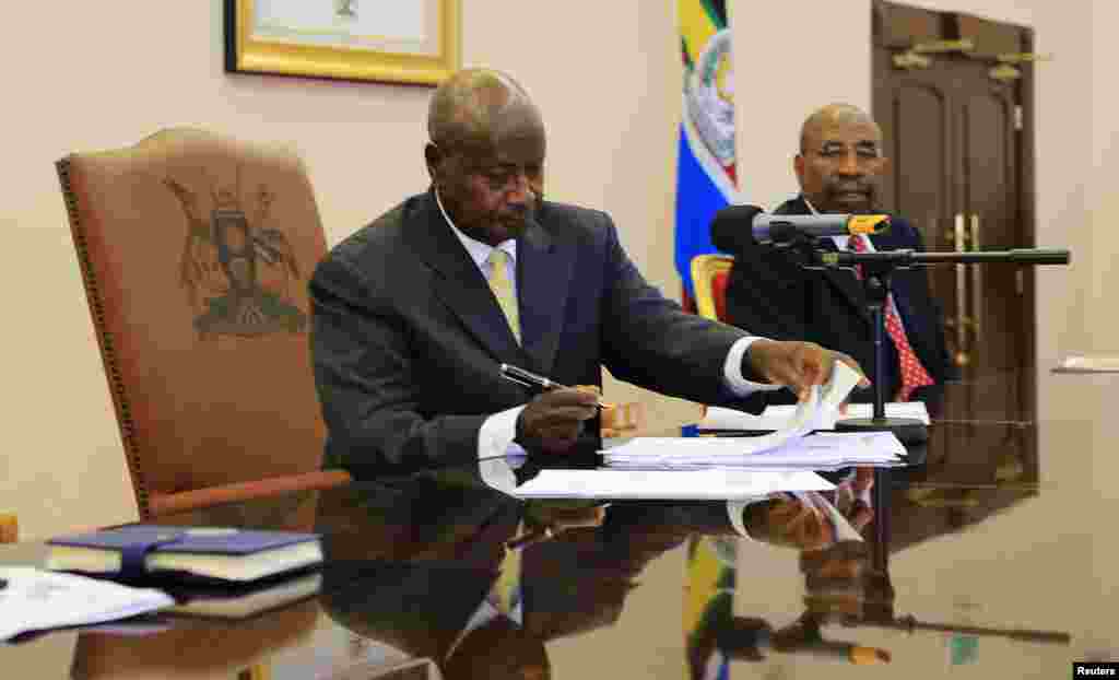 Uganda President Yoweri Museveni signs an anti-homosexual bill into law at the state house in Entebbe, 36 km (22 miles) south west of capital Kampala.