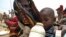 A mother quenches her child's thirst while waiting for food handouts at a health center in drought-stricken remote Somali region of Eastern Ethiopia.