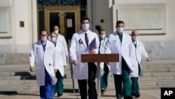 Dr. Sean Conley, physician to President Donald Trump, center, and other doctors, walk out to talk with reporters at Walter Reed National Military Medical Center, Monday, Oct. 5, 2020, in Bethesda, Md. (AP Photo/Evan Vucci)