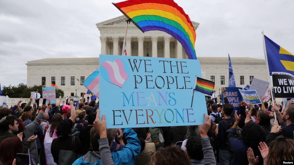 FILE - LGBTQ activists and supporters hold a rally outside the U.S. Supreme Court as it hears arguments in a major LGBTQ rights case in Washington, Oct. 8, 2019.
