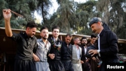 FILE - Kakai men dance during a festival in Mosul, Iraq, Sept. 27, 2019.