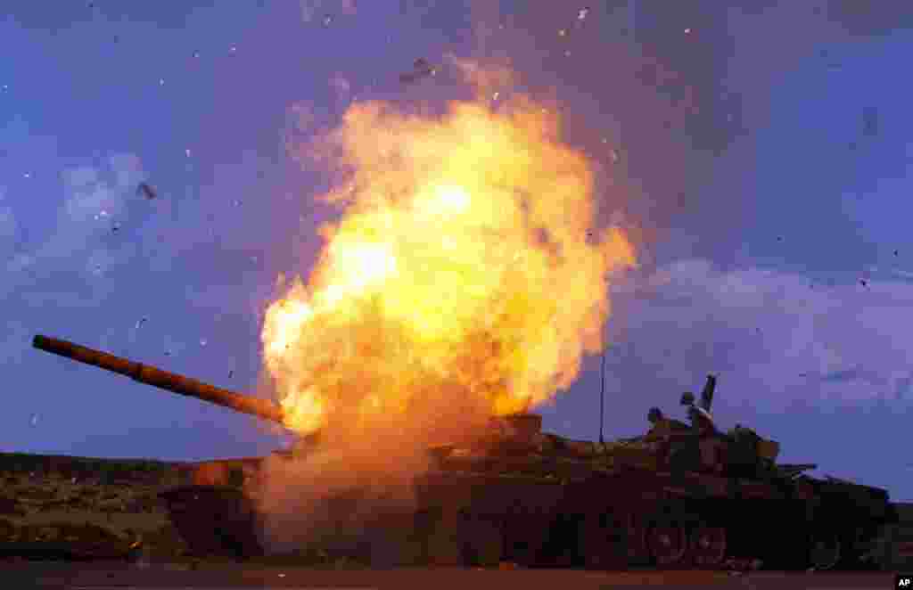 A tank belonging to forces loyal to Libyan leader Muammar Gaddafi explodes after an air strike by coalition forces, along a road between Benghazi and Ajdabiyah March 20, 2011. REUTERS/Goran Tomasevic (LIBYA - Tags: POLITICS CIVIL UNREST CONFLICT IMAGES OF