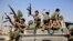 FILE - Houthi fighters ride on a patrol truck as they chant slogans during a tribal gathering in Sana'a, Yemen, Dec. 14, 2015. 