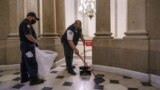 Workmen clean up outside the office of Speaker of the House Nancy Pelosi the day after violent protesters loyal to President Donald Trump stormed the U.S. Congress, at the Capitol in Washington, Jan. 7, 2021. (AP Photo/J. Scott Applewhite)
