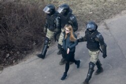 fFILE - Police officers detain a demonstrator as they prevent an opposition action to protest the official presidential election results in Minsk, Belarus, March 27, 2021.