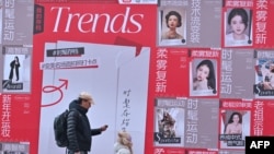 People walk past advertising for Chinese social networking and e-commerce app Xiaohongshu, also known as RedNote, at a shopping center in Beijing, Jan. 15, 2025.