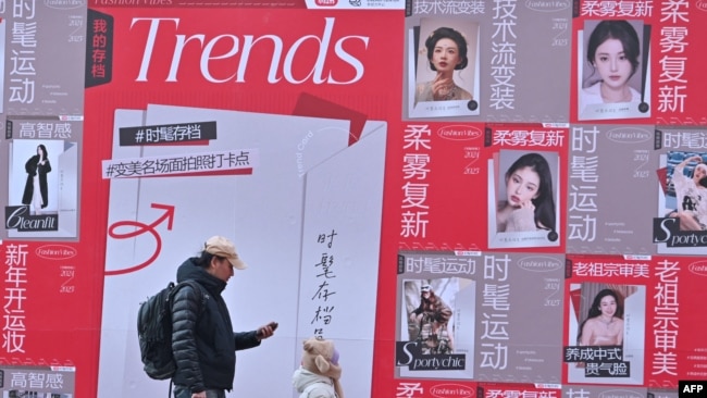 People walk past advertising for Chinese social networking and e-commerce app Xiaohongshu, also known as RedNote, at a shopping center in Beijing, Jan. 15, 2025.