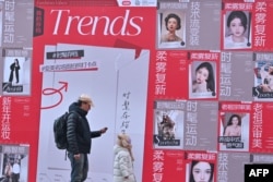 People walk past advertising for Chinese social networking and e-commerce app Xiaohongshu, also known as RedNote, at a shopping center in Beijing, Jan. 15, 2025.