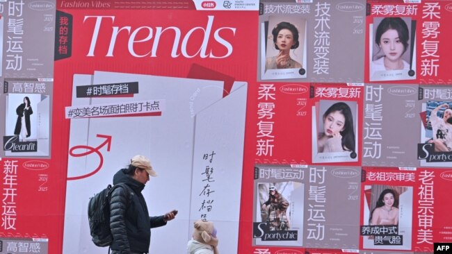 La gente pasa junto a la publicidad de la aplicación de comercio electrónico y redes sociales china Xiaohongshu, también conocida como RedNote, en un centro comercial de Beijing el 15 de enero de 2025.