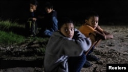 Migrantes menores no acompañados de Honduras a la orilla del río mientras esperan ser escoltados por la Patrulla Fronteriza después de cruzar el río Grande hacia Estados Unidos desde México, 9 de julio de 2021.