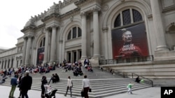 People sit on the steps at the Fifth Avenue entrance to the Metropolitan Museum of Art in New York, May 10, 2017. 