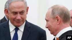 Russian President Vladimir Putin, right, and Israeli Prime Minister Benjamin Netanyahu talk to each other during their meeting in the Kremlin in Moscow, Russia, May 9, 2018.