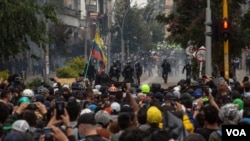 La policía antidisturbios y los manifestantes se enfrentan durante una protesta nacional contra la reforma tributaria en Bogotá, Colombia, el 28 de abril de 2021. [Foto: VOA/Pu Ying Huang]