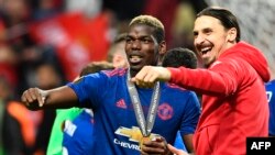 Le milieu de terrain français de Manchester United, Paul Pogba, célèbre sa médaille avec l'attaquant suédois de Manchester United Zlatan Ibrahimovic, à droite, après le dernier match de football de l'UEFA Europa League Ajax Amsterdam contre Manchester Uni