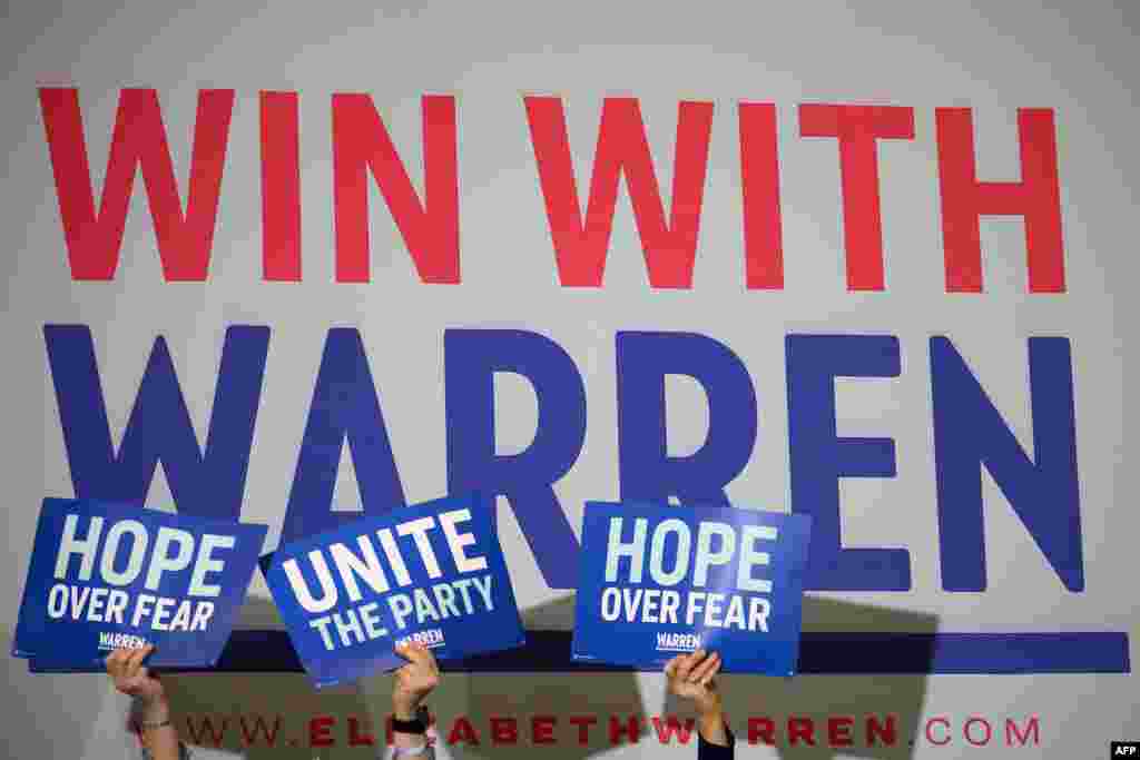 Supporters hold up placards as Democratic presidential candidate Massachusetts Senator Elizabeth Warren speaks at a town hall in Davenport, Iowa, on Feb. 1, 2020.