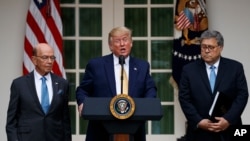 President Donald Trump, joined by Commerce Secretary Wilbur Ross, left, and Attorney General William Barr, speaks during an event about the census in the Rose Garden at the White House in Washington, July 11, 2019. 