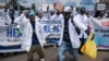 Kenyan doctors chant outside the health ministry headquarters protesting with placards to demand better pay and working conditions in the capital, Nairobi, on April 9, 2024.