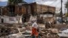 A woman walks past debris from houses during a planned demolition in the historical Piazza neighbourhood of Addis Ababa on March 14, 2024.