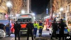 Police guard the scene in front of a restaurant in central Hanau, Germany, Feb. 20, 2020. German police say several people were shot to death in Hanau Wednesday evening.
