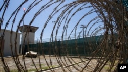 ARCHIVO - Imagen tomada en 2019, revisada por los militares, muestra una torre de control y alambradas de púas en un sector del centro de detención de la Base de Guantánamo, en Cuba.