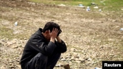 FILE - A father reacts after his son was killed in an airstrike during a battle between Iraqi forces and Islamic State militants, in Mosul, Iraq, March 17, 2017.