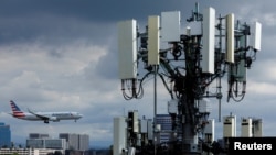 An American Airlines commercial aircraft flies past a cell phone tower as it approaches to land at John Wayne Airport in Santa Ana, California U.S. January 18, 2022. 