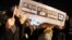 People hold a placard which reads "I am Muslim, I am Jewish, I am Catholic, I am Charlie" at a vigil, following the shooting of 12 people at the satirical newspaper Charlie Hebdo, at the Place de la Republic in Paris, Jan. 8, 2015.