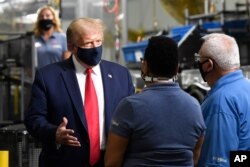President Donald Trump wears a mask as he talks with employees as he tours the Whirlpool Corporation facility in Clyde, Ohio, Aug. 6, 2020.
