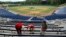 Workers use tape to block off seats as they prepare for a large high school graduation ceremony at Hoover Metropolitan Stadium in Hoover, Ala., May 19, 2020. 