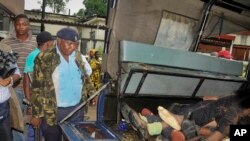 Afisa wa polisi akilinda maiti za watu sita walouliwa waliposhambulia kambi ya jeshi Mombasa, Kenya Jumapili Nov 2, 2014 