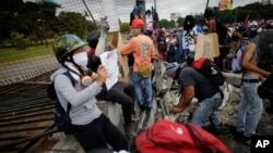 Manifestantes derribaron una cerca de la base aérea La Carlota durante una protesta en las afueras de Caracas, el sábado, 24 de junio de 2017.
