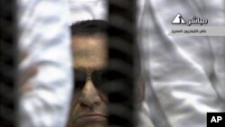 In this video image taken from Egyptian State Television, 84-year-old former Egyptian president Hosni Mubarak is seen in the defendant's cage as a judge reads the verdict in on charges of complicity in the killing of protesters during last year's uprising