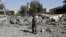 FILE - A police trooper walks on the rubble of a building destroyed by Saudi-led air strikes at Sana'a Airport in Sana'a, Yemen, Dec. 21, 2021. 