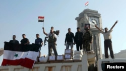 Fighters loyal to the Assad regime hold up the Syrian national flag stand June 5, 2013 after capturing the town of Qusair from anti-government rebels.