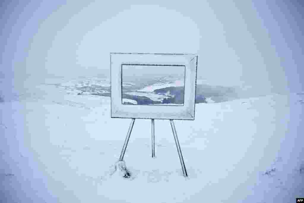 Fog and snow surround an art installation, giving a pictured-framed view over the valley beneath, at the summit of Holme Moss in the Peak District, in northern England,&nbsp;after snow and rain continued to fall across parts of the United Kingdom.&nbsp;