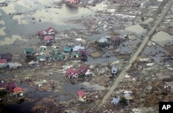 Rumah-rumah yang hancur akibat hantaman gelombang tsunami di kota Meulaboh, provinsi Aceh, 1 Januari 2005. (Dudi Anung, Arsip/AP)